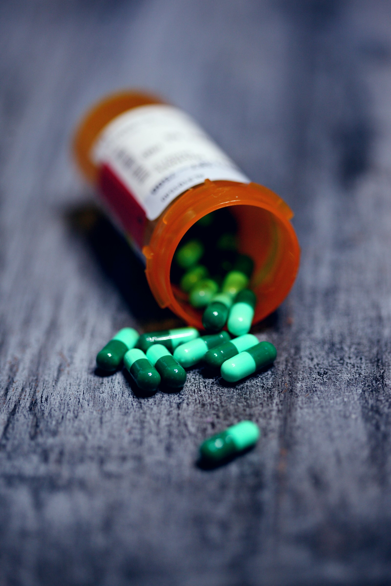 Capsules spilling from an open prescription bottle